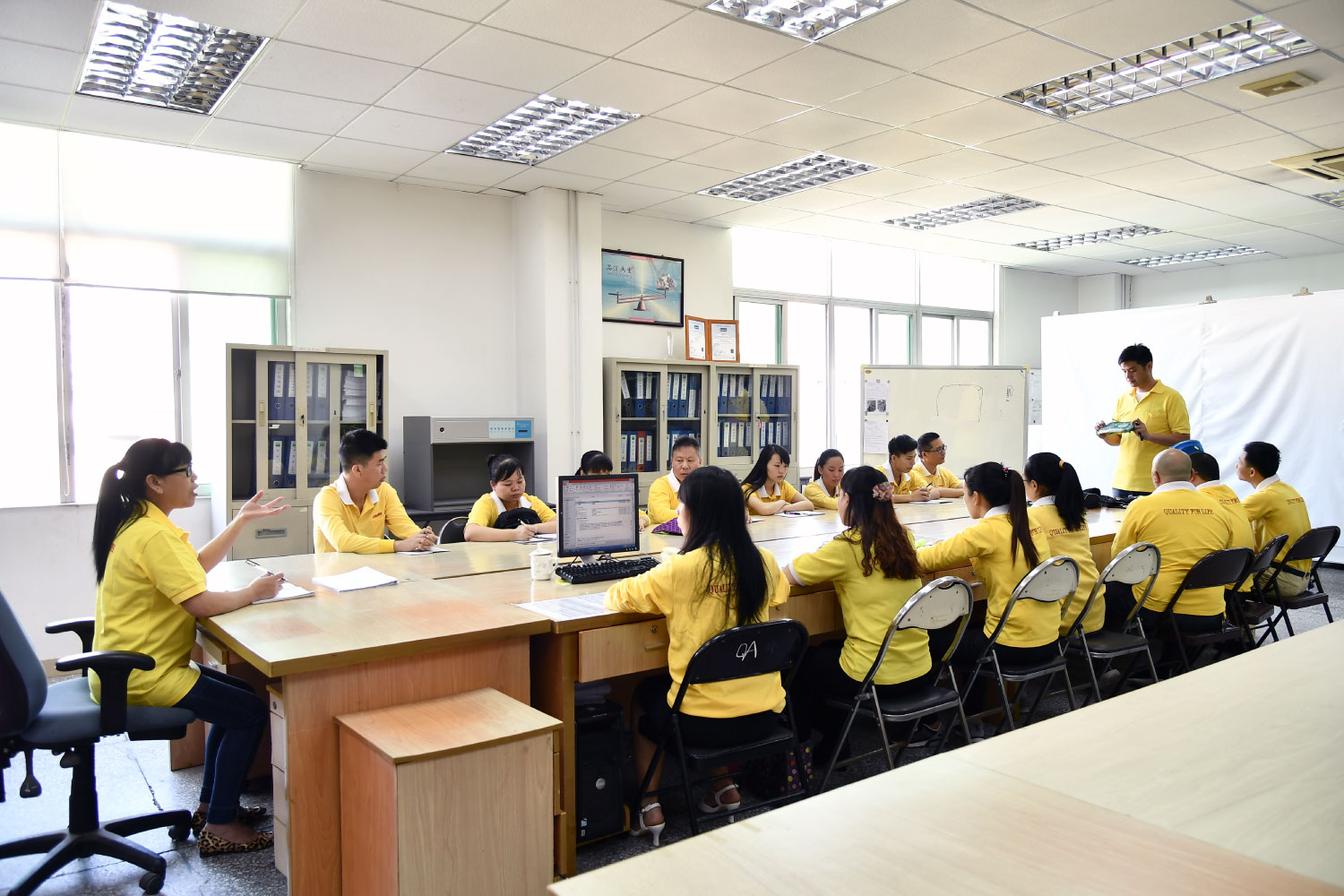 Meeting of quality control department explaining in detail how to check a specific bag part in the production line